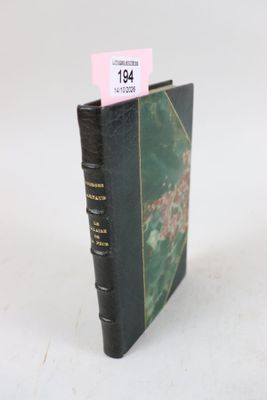 un vieux livre orné d'une étiquette rose, posé sur une surface blanche