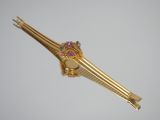 a gold hair clip with colorful stones on it