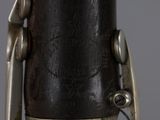 close up of a bassoon with a black body and a silver handle