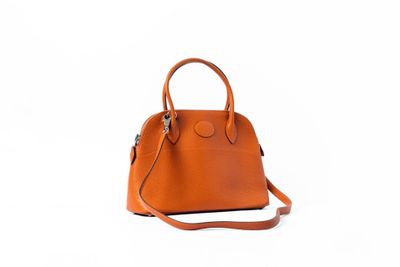 un sac à main orange sur fond blanc