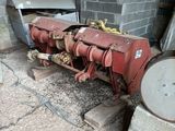 un tracteur rouge garé à côté d'un bâtiment