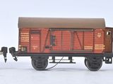 trois wagons de train miniature posés côte à côte sur une surface blanche