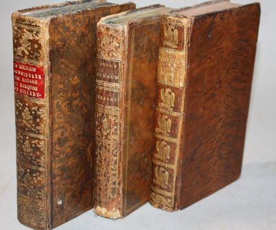 two old books sitting on top of each other on a table