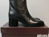 une paire de bottines noires posée sur une boîte