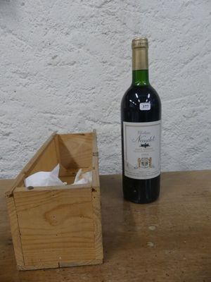 une bouteille de vin posée sur une table à côté d'une caisse en bois