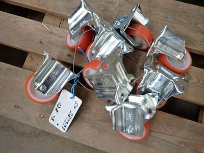 plusieurs morceaux de métal et des roues orange posés sur une palette en bois