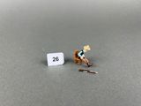 a miniature figurine of a man sitting on a chair next to a sign