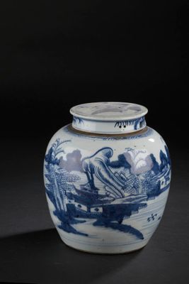 un vase bleu et blanc posé sur une surface noire