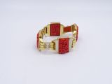 gold and red bracelet with a flower design on the front