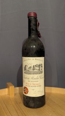 a bottle of wine sitting on top of a wooden table