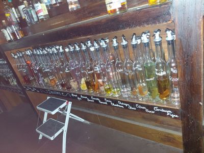 many bottles of alcohol lined up on a shelf