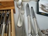 silverware and spoons on a table with a picture on the wall
