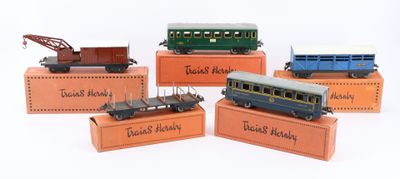 five toy trains on display on a white surface