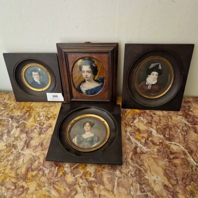 trois portraits de femmes encadrés sont posés sur une surface en marbre