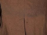 a close up of a man wearing a brown suit and tie