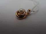 a close up of a necklace with a pearl on it