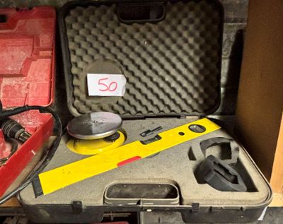 une caisse d'outils avec des outils à l'intérieur, posée sur le sol