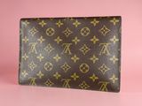 a brown louis vuitto wallet on a pink background