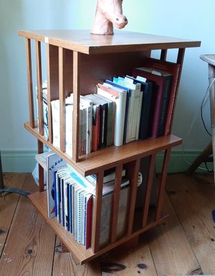 une bibliothèque en bois sur laquelle sont posés des livres et surmontée d'une tête de cheval
