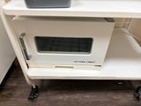 a microwave sitting on top of a cart in the kitchen