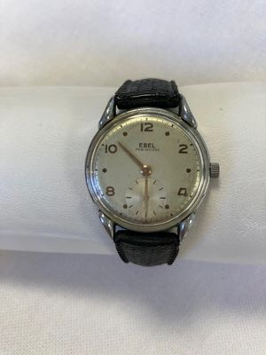 a silver watch sitting on a white napkin on a table
