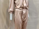 the mannequin is wearing a pink suit and pants on a stand