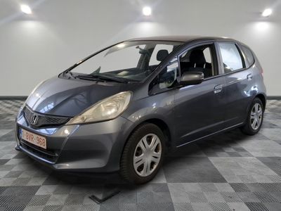 une photo d'une petite voiture grise garée dans un garage