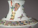 a vase that has a bird and flowers on it