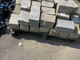 a pile of bricks sitting on the ground next to a pile of soda cans