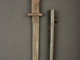 an old knife and a small metal object on a gray surface