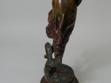 bronze statue of a woman holding a bird on a wooden base