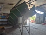 une grande benne verte posée dans un garage