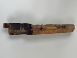 wooden carving of a man on a log with a knife in his hand