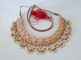 un gros plan sur un collier en or orné d'un pompon rouge