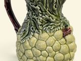 une cruche verte et marron ornée d'un motif de feuilles