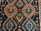 a blue and orange rug with a diamond design on it