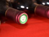 several bottles of wine are lined up on a red surface