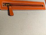 an orange and white purse sitting on top of a table