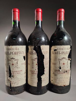 trois bouteilles de vin rouge posées côte à côte sur une table