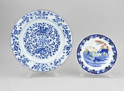 two blue and white plates with designs on them sitting on a table