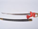 two knives on a white surface with a red handle