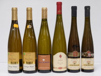 six bottles of wine are lined up in a row on a white surface