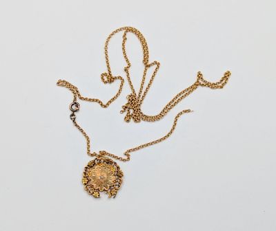 une photo d'un collier en or orné d'un motif floral