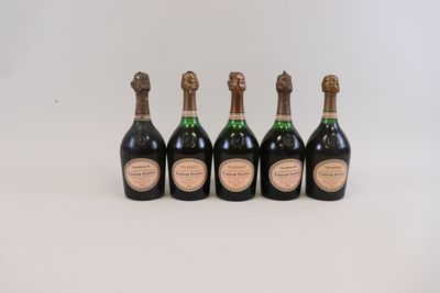 quatre bouteilles de champagne sont alignées sur une surface blanche