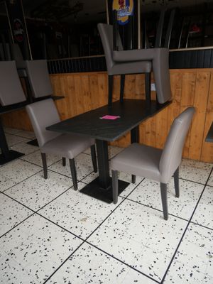 a table and chairs in a restaurant with a sign on it
