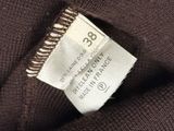 the label of a brown sweater with a white tag on it