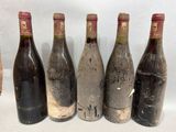 six bouteilles de vin sont alignées sur une table