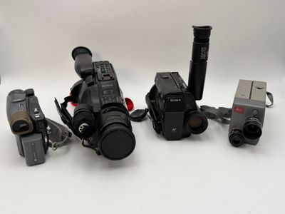 many different cameras that are sitting on a white surface