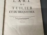 un vieux livre posé sur une table à côté d'une tasse de café