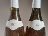 two bottles of wine sitting next to each other on a table